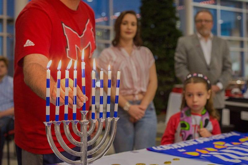Maryville Hillel student lighting a candle during Hanukkah